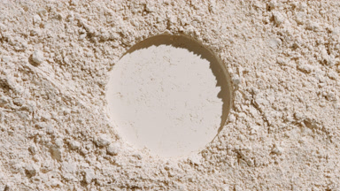 Beige Powder Surface with Central Round Imprint and Shadows