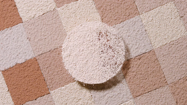 Beige Powder Sifted in Circular Motion Over Skin Tones