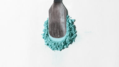 Cyan Powder Heap Close-Up on Pale Grey Background
