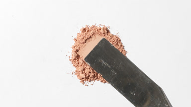 Close-Up of Beige Powder Being Smoothed