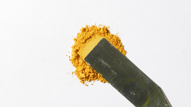 Yellow Powder Heap Smeared on Light Gray Backdrop