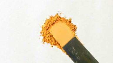 Extreme Close-Up of Yellow Powder on Grey Background