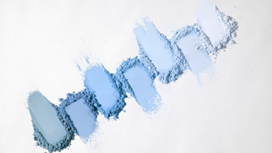 Overhead View of Seven Blue Powder Heaps on Soft Gray