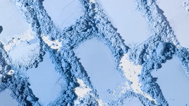 Macro Close-Up of Blue Powder Heaps on Muted Grey