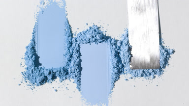 Blue Powder Heaps Dragged with Knife on Light Gray Surface