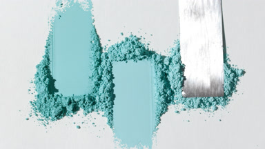Cyan Powder Heaps Spread Thin on Pale Gray Canvas