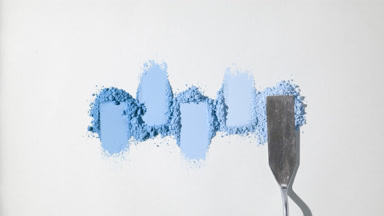 Overhead View of Blue Powder Heaps on Muted Grey