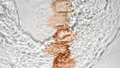 Slow-Motion Water Flow Over Beige Powder Heaps