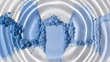 Water Droplet Forming Ripples on Blue Powder Heaps