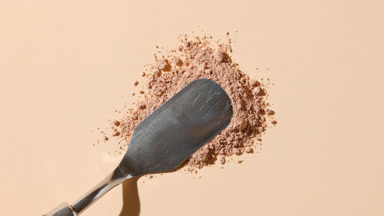 Macro Close-Up of Beige Loose Powder on Grey Background