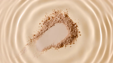 Slow-Motion Droplet Ripple on Beige Powder for Promotion