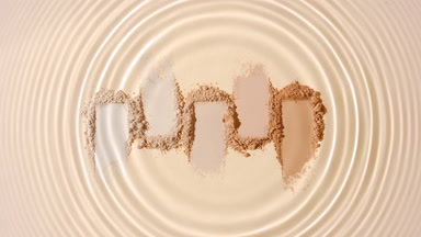 Water Droplet Creating Circles Over Beige Powder