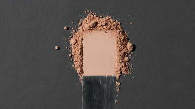 Close-Up of Beige Loose Powder on Light Grey Surface
