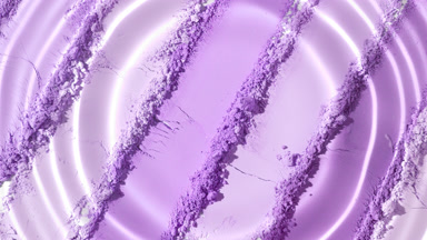 Water Droplet Creating Ripple Patterns on Violet Powder