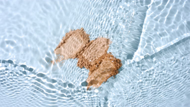 Slow Motion Water Splashing on Three Beige Smears