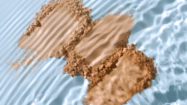 Extreme Close-Up of Water Stream on Beige Powder Smears