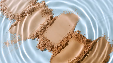 Water Droplet Creating Ripples on Beige and Brown Powders