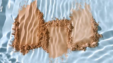 Slow Motion Splash of Water Over Skintone Powder on Blue