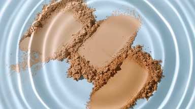 Extreme Close-Up of Droplet Creating Waves on Skin Tone Powders