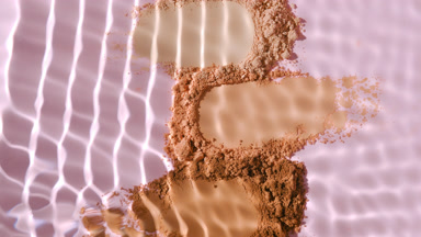 Dynamic Water Splashing Over Skintone Powder on Pink Background