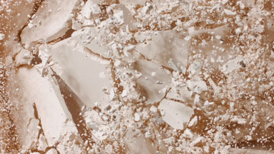 Flattened Beige Powder Surface Bursting from Below