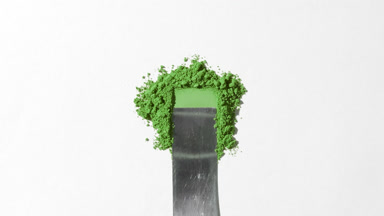Green Powder Heap Smeared on Light Grey Background