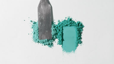 Cyan Powder Heaps on Light Grey Surface