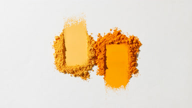 Macro Shot of Orange and Yellow Powder Heaps on Grey