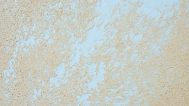 Dynamic Close-Up of Greenish Beige Powder on Blue Surface