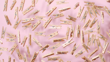 Clothespins Tossed Upward in Slow Motion on Pink Surface