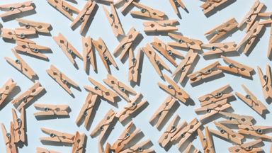 Dynamic Shadows from Tiny Wooden Pins on Pale Blue Background