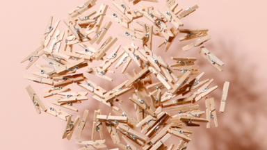 Tumbling Wooden Clothespins on Beige Canvas