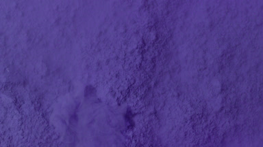 Violet Powder Dispersing Underwater in Macro View