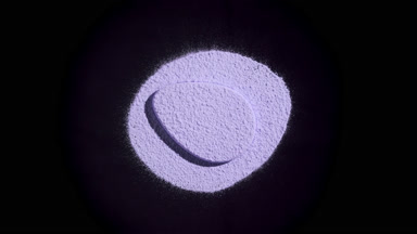 Violet Powder and Puff Illuminated on Black Background