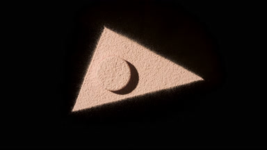 Beige Face Powder Triangle on Black Surface