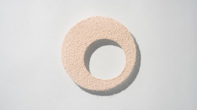 Shifting Shadows of Beige Powder on Light Gray Backdrop