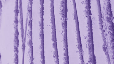 Vertical Orbit Shot of Violet Powder Surface with Shadows