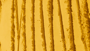 Tracking Vertical Shot of Yellow Powder Surface with Patterns