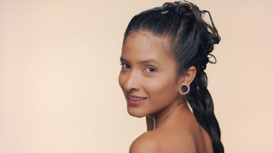 Latin american woman with bronzed smooth skin look over shoulder