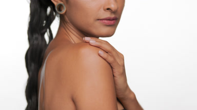 Spanish woman with bronzed skin illustrates moisturized skin