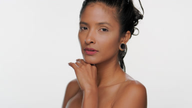 South american woman with light brown skin touches chin