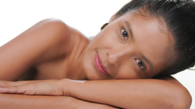 Argentinian woman with light brown skin leans on forearm