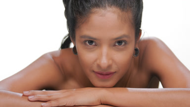 Spanish origin woman with tan soft skin rests chin on forearm