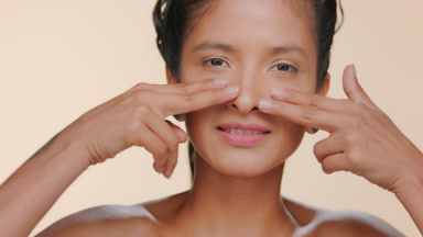 Latin woman light brown elastic skin strokes under-eye beige bg