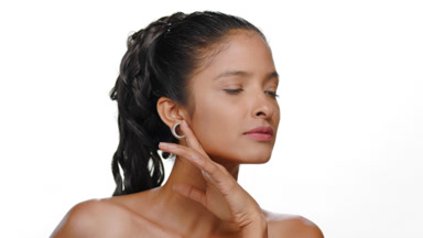 Argentinian woman honey skin tone gently strokes jawline