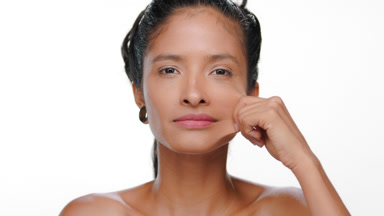 Latin american woman bronzed skin stretches cheek elastic skin