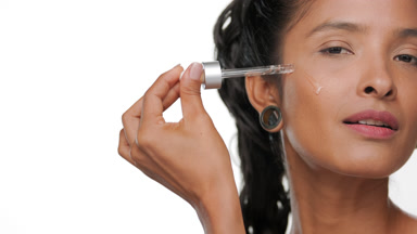Argentine woman applies moisturizing face serum warm skin tone