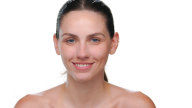 Young latina with fair freckled skin turns to camera on white