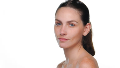 Latina with light skin and freckles looks over shoulder on white