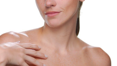 Fair-skinned beauty model with freckles strokes clavicles